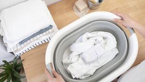 In einem Wäschekorb, der auf einer Arbeitsplatte aus Holz steht, liegt weisse Wäsche.