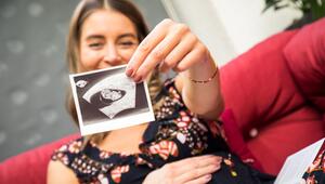Eine schwangere Frau zeigt ein Ultraschallbild