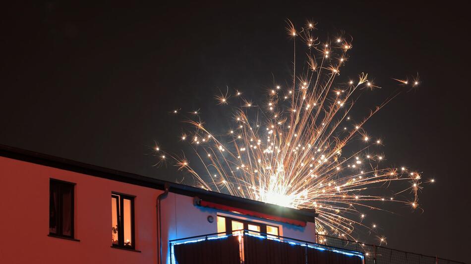 Feuerwerk über einem Wohnhaus in der Silvesternacht