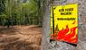 Ein Schild im Wald weist auf die Waldbrandgefahr hin