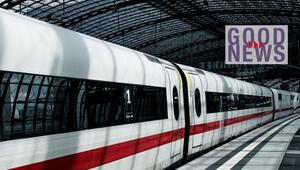 Weisser Hochgeschwindigkeitszug mit rotem Streifen, der in einer modernen Bahnhofshalle mit ...