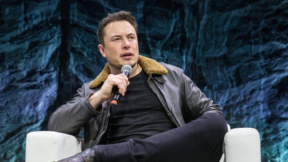 Elon Musk auf einem Stuhl.