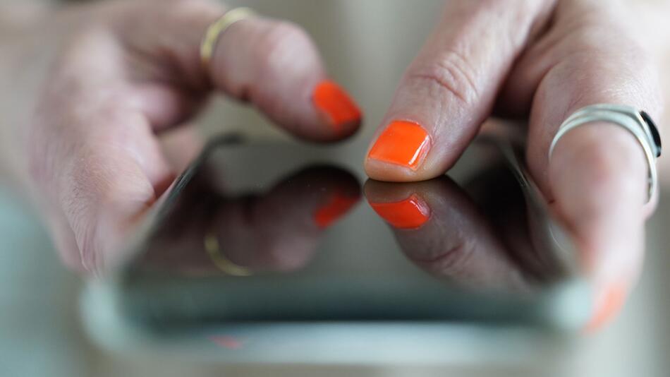 Frau tippt auf einem Smartphone