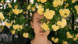 Eine Junge Frau hinter Blumen im Park