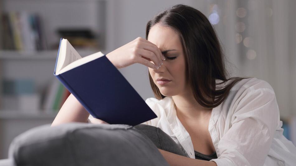 Eine Freu liest genervt ein Buch.