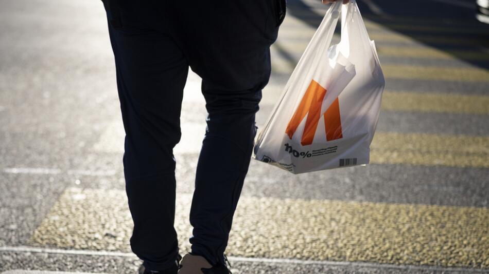 Person geht mit Plastiksack einkaufen