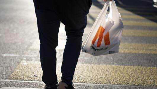 Person geht mit Plastiksack einkaufen