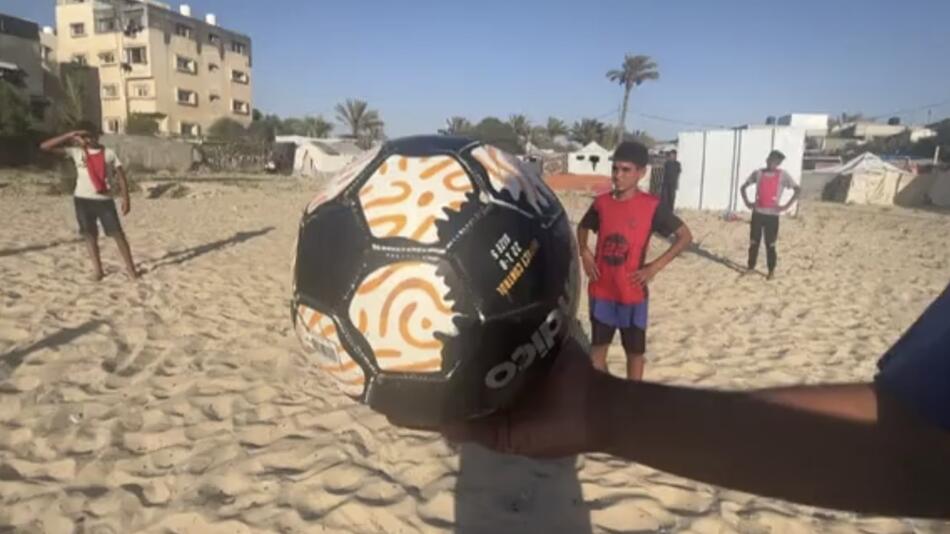 Kinder in Gaza spielen am Strand Fussball.