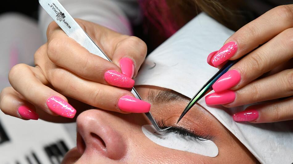 Bei einem Model wird eine Wimpernverlängerung gemacht