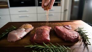 Eine Perosn würzt Fleisch