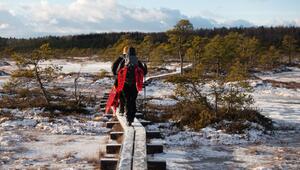 Mit geschulterten Schneeschuhen geht es durch das Moor Kakerdaja