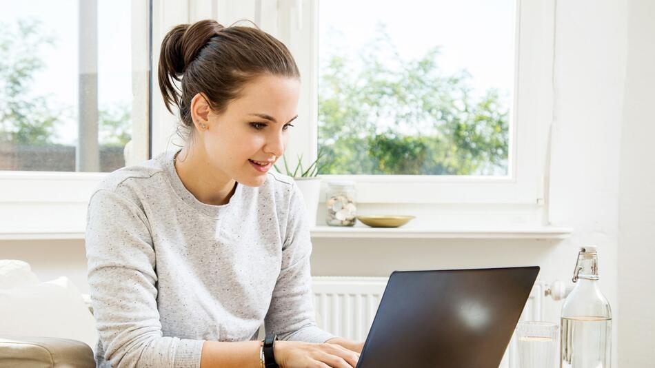 Eine junge Frau arbeitet an einem Laptop