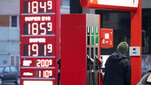 Mann betankt an einer Tankstelle vor einer Preistafel ein Auto