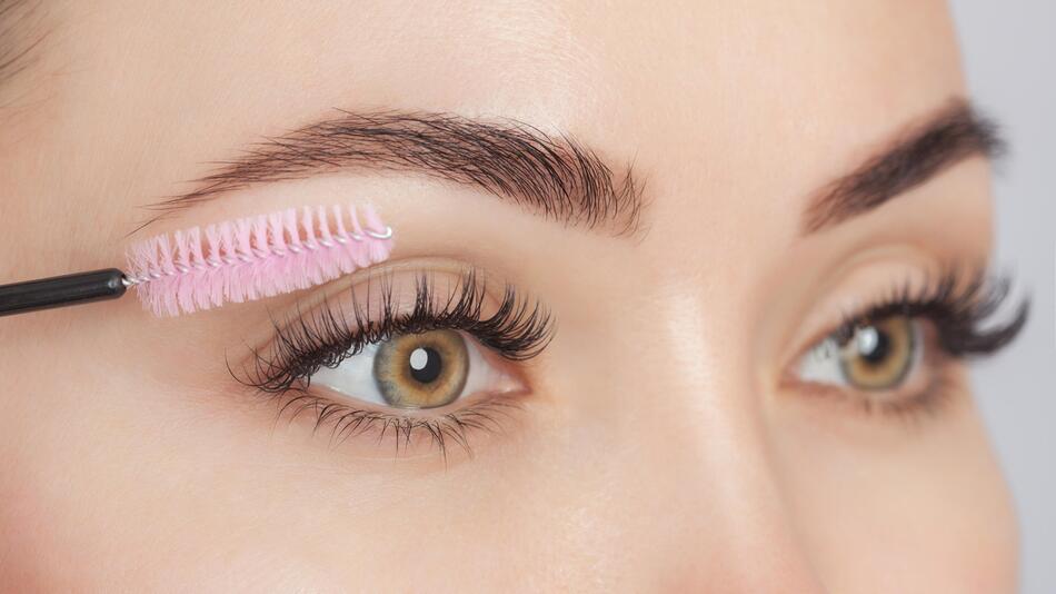 Augen einer Frau mit Wimpernbürste