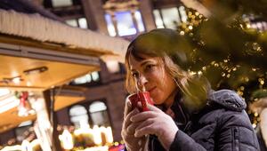 Frau trinkt auf dem Weihnachstmarkt ein Heissgetränk