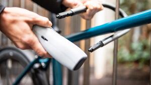 Person schliesst ein Fahrrad an einem Zaun an