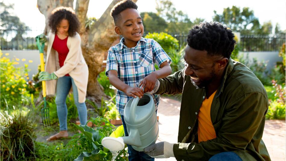 Familie arbeitet gemeinsam im Garten.