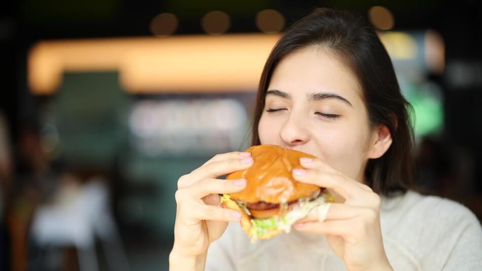 Frau isst einen Hamburger