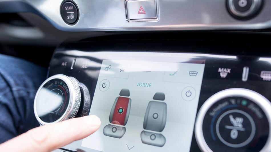 Mann bedient ein Touchdisplay im Auto