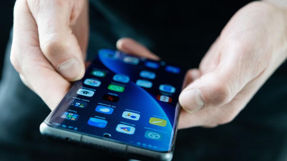 Ein Mann hält ein Android Smartphone in den Händen