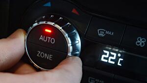 Ein Mann dreht an dem Einstellrad für die Klimaanlage im Auto