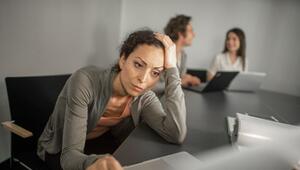Frau sitzt grübelnd vor ihrem Laptop im Büro