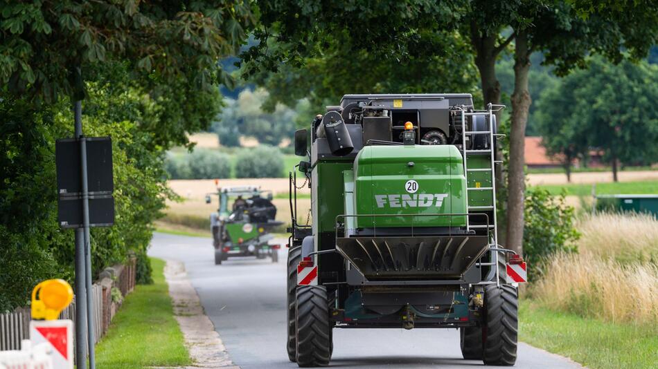 Landwirt fährt mit seinem Mähdrescher auf einer Landstrasse