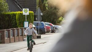 Junge fährt mit dem Fahhrad auf einer Strasse