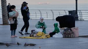 Eine vertriebene Familie sitzt auf einem Bürgersteig an der Corniche von Beirut.