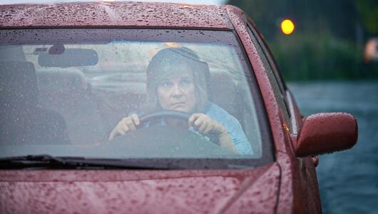 Frau bei gewitter besorgt im Auto