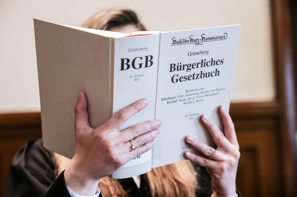 Richterin liest im Gerichtssaal im Bürgerlichen Gesetzbuch