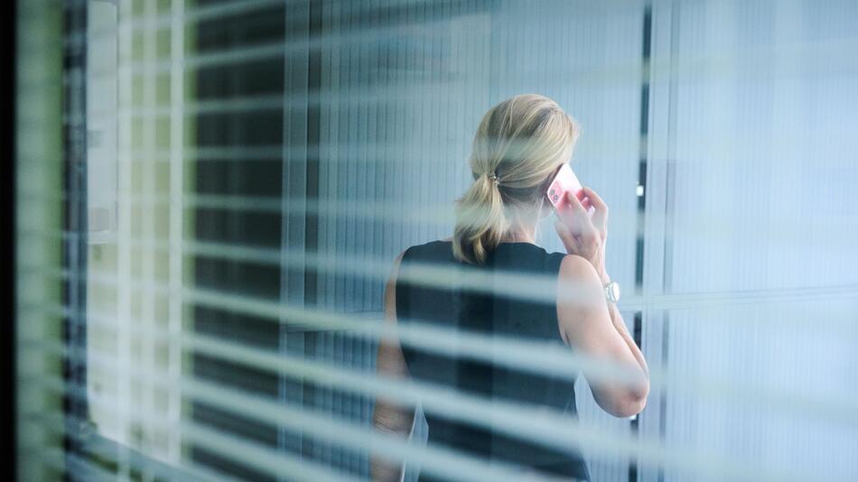 Frau steht im Büro und telefoniert