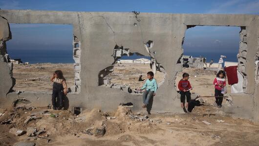 Kinder vor einem zerstörten Haus