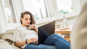 Frau sitzt mit einer Kreditkarte vor einem Laptop
