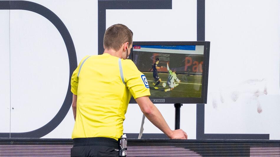 Ein Bundesliga-Schiedsrichter schaut sich eine Spielszene auf dem Monitor an