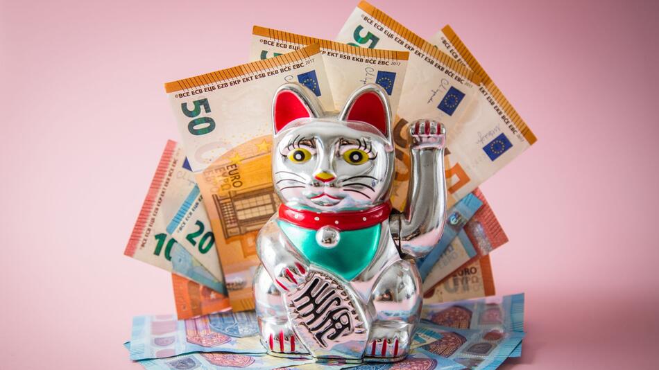 Japanische Glückskatze Maneki-neko mit Geldscheinen