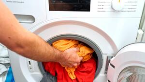 Buntwäsche wird in die Waschmaschine gegeben.