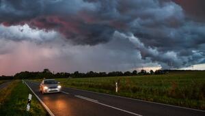 Gewitterzelle zieht im Sonnenuntergang über eine Landstrasse