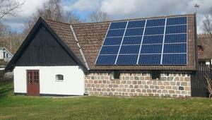 Ein Haus mit einer Fassade aus weissen und steinernen Mauern, braunen Doppeltüren und kleinen ...