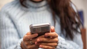 Eine junge Frau hält ein Smartphone in den Händen
