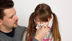 Ein Vater hilft seiner Tochter beim Naseputzen