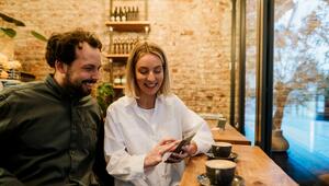 Frau und Mann schauen aufs Handy und schmunzeln 