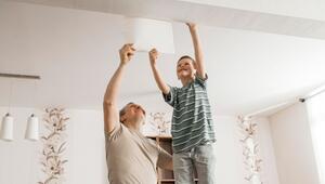 Vater und Sohn tapezieren gemeinam in der Wohnung
