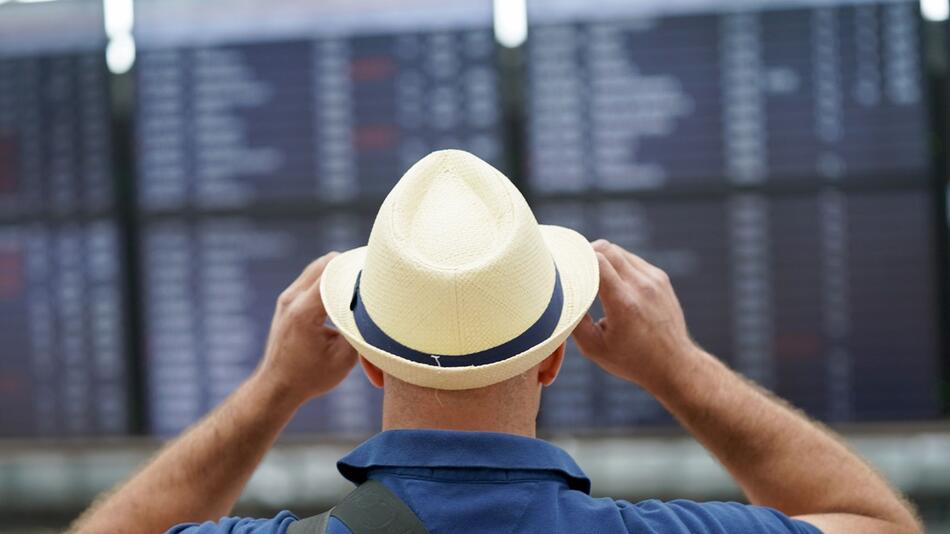 Ein Flugreisender steht vor den Check-In-Schaltern