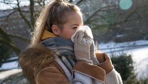 Frau putzt sich im Park die Nase