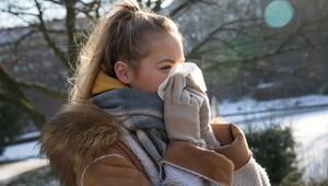 Frau putzt sich im Park die Nase