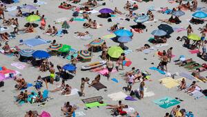 Menschen nehmen einen Sonnenbad am Strand Cala Pi