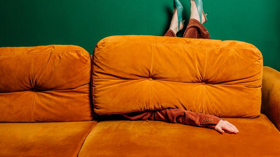 EIne Frau ist teilweise verdeckt von einem Sofa