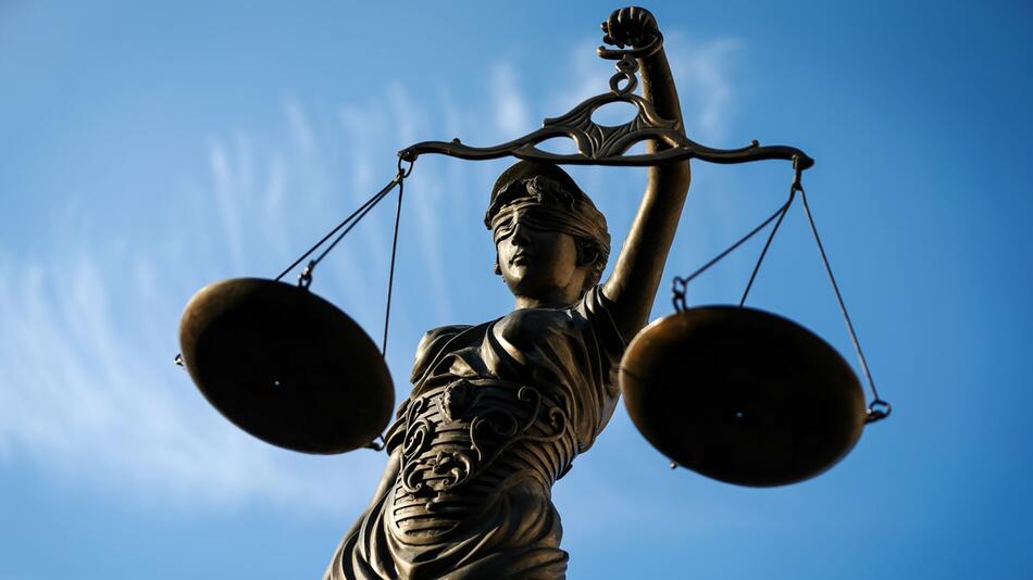 Eine Statue der Justitia hält eine Waage in der Hand