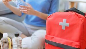 Frau mit Wasserflaschen und medizinischem Notfallset 